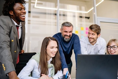A diverse group of law professionals collaborating around a laptop in a modern office setting